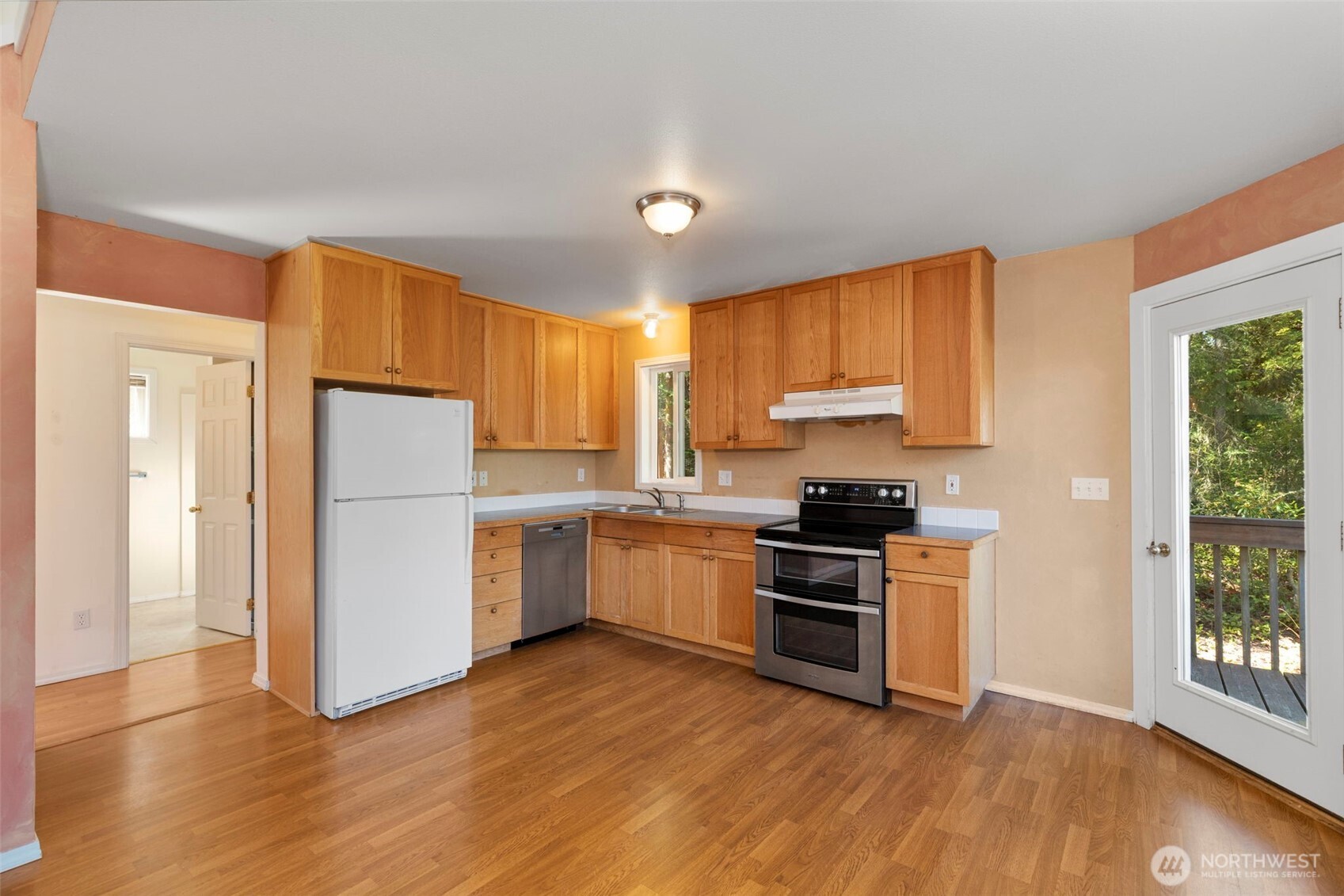 4375 Erin Street Port Townsend, WA 98368 - Photo 35 of 40 a kitchen with a stove a sink dishwasher a refrigerator and a microwave oven with wooden floor
