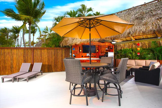 a living room with patio furniture and a potted plant
