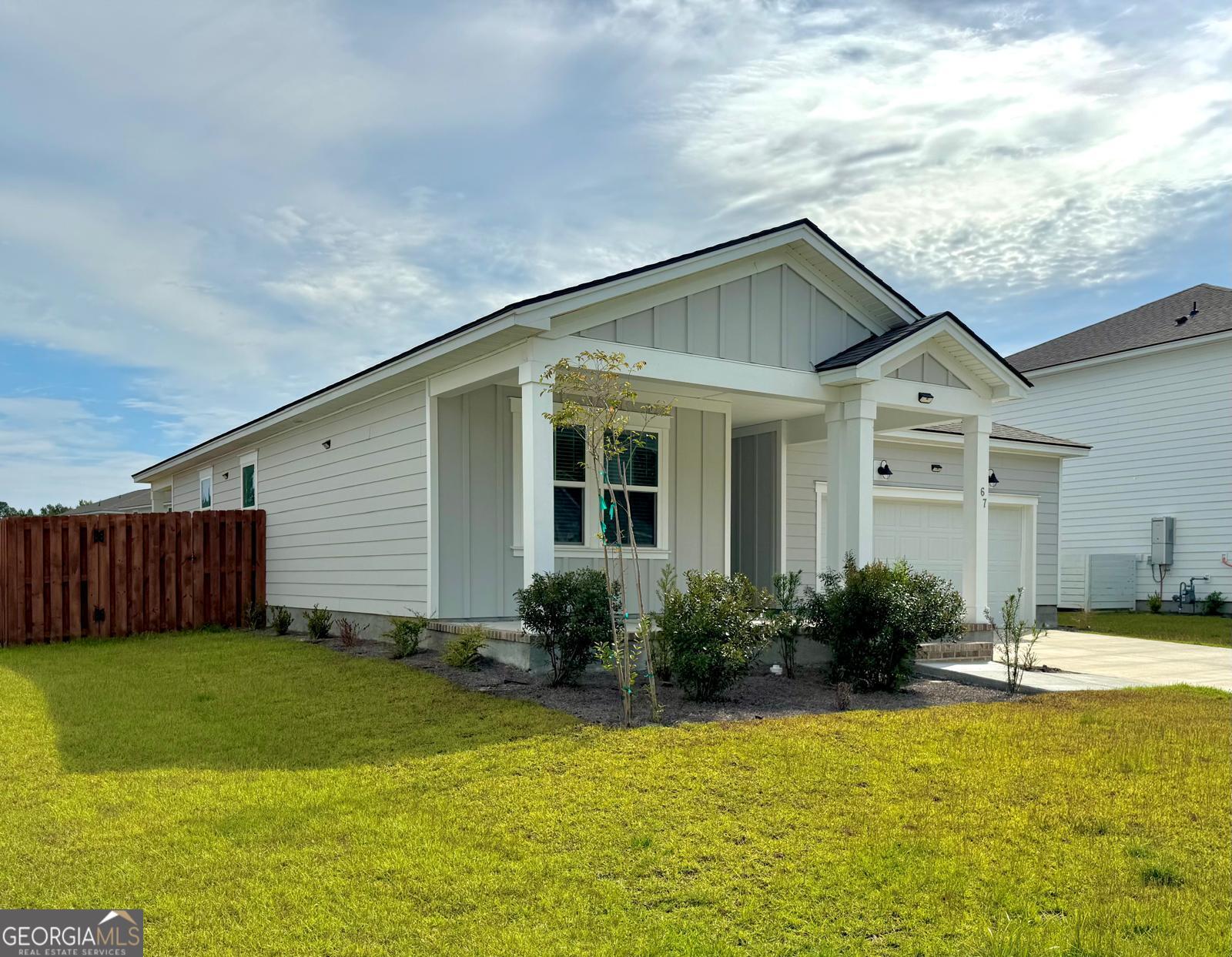 67 Shade Tree Drive Richmond Hill, GA 31324 - Photo 2 of 25 a front view of house with yard and swimming pool