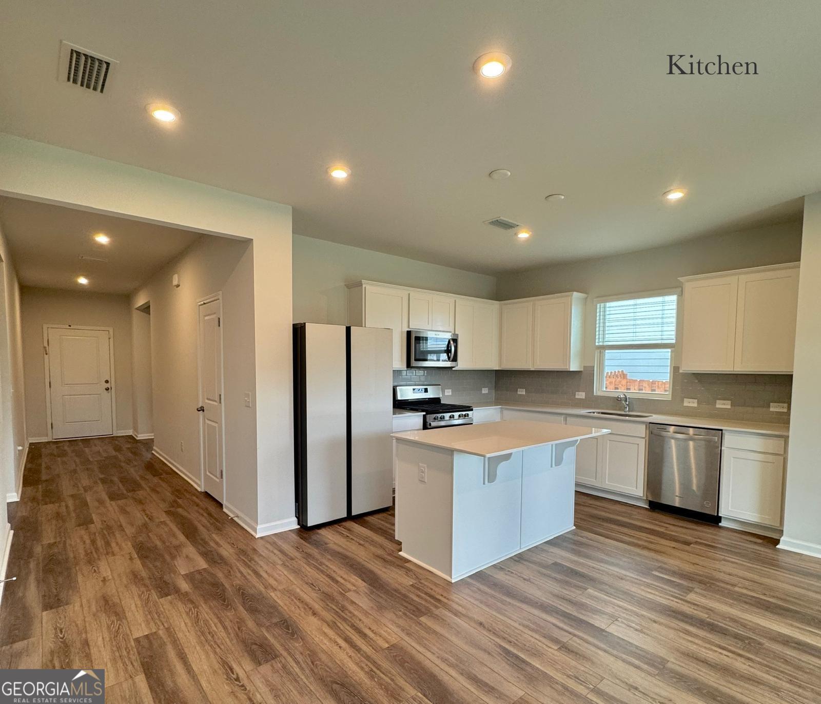 67 Shade Tree Drive Richmond Hill, GA 31324 - Photo 5 of 25 a kitchen with stainless steel appliances granite countertop a stove top oven a refrigerator a sink and a refrigerator