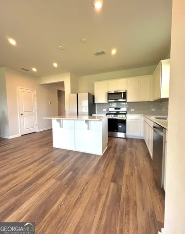 a large kitchen with stainless steel appliances granite countertop a stove and a refrigerator