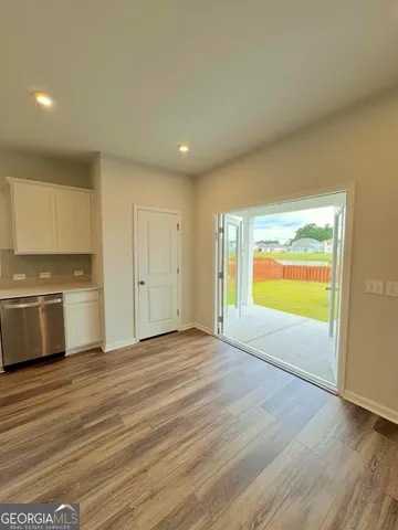a view of an empty room with a kitchen and a window