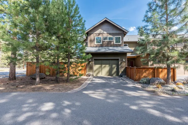 a view of a house with a yard and large tree
