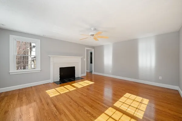 a view of an empty room with window and fire place