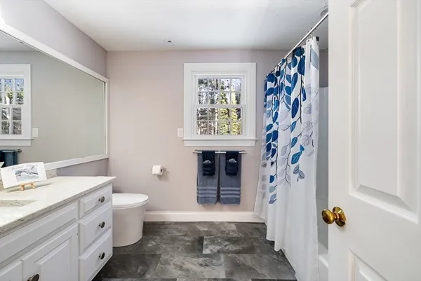 a bathroom with a granite countertop sink toilet and shower