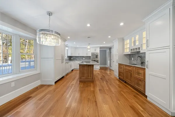 a large kitchen with kitchen island a large counter space stainless steel appliances and cabinets