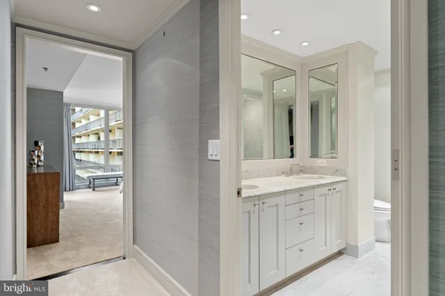 a bathroom with a granite countertop double vanity sink a mirror and a toilet