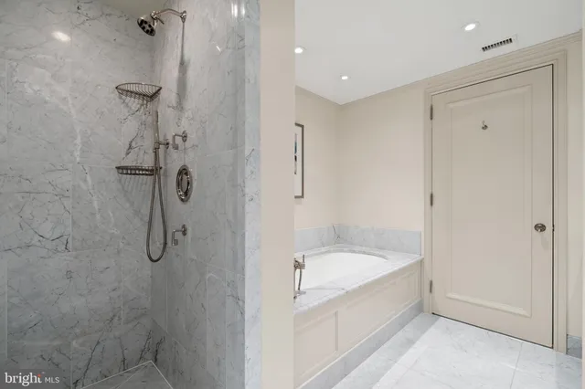a bathroom with a granite countertop tub sink and mirror