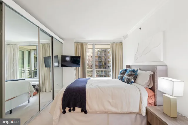 a bedroom with a large bed and a flat tv screen