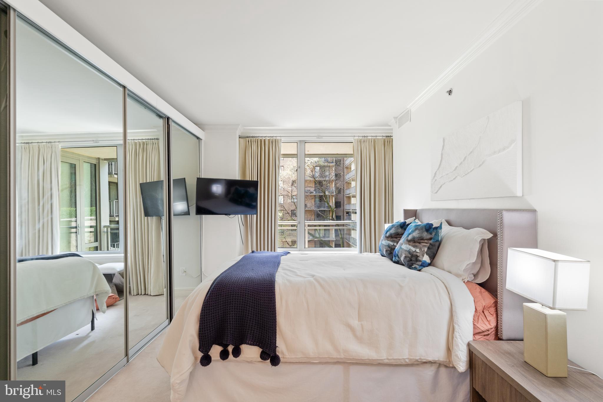 1111 23rd Street Northwest, Unit 4C Washington, DC 20037 - Photo 37 of 45 a bedroom with a bed and large windows