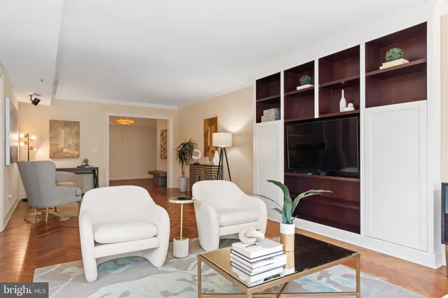 a living room with furniture a flat screen tv and kitchen view
