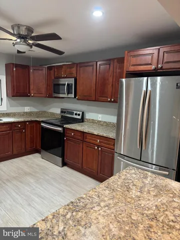 a kitchen with stainless steel appliances granite countertop a refrigerator and a sink