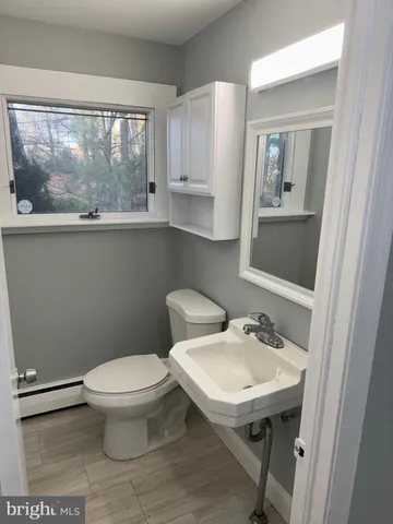 a bathroom with a toilet a sink and a mirror