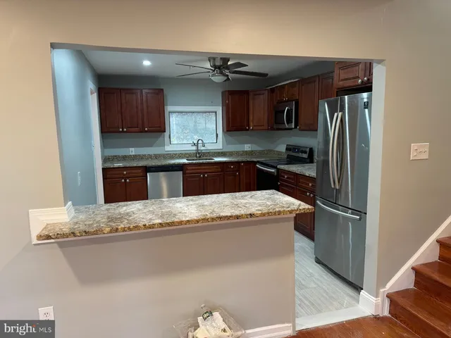 a kitchen with granite countertop a refrigerator sink and stove