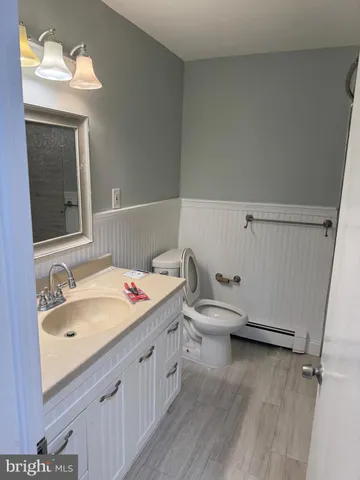 a bathroom with a granite countertop sink mirror and toilet