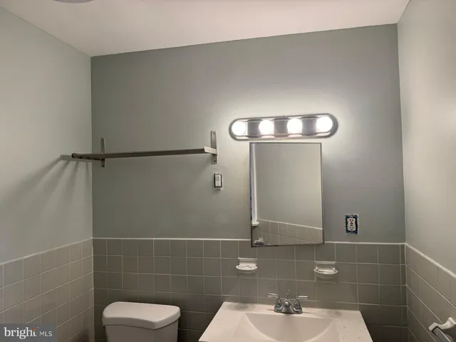 a bathroom with a sink a light fixture and a mirror