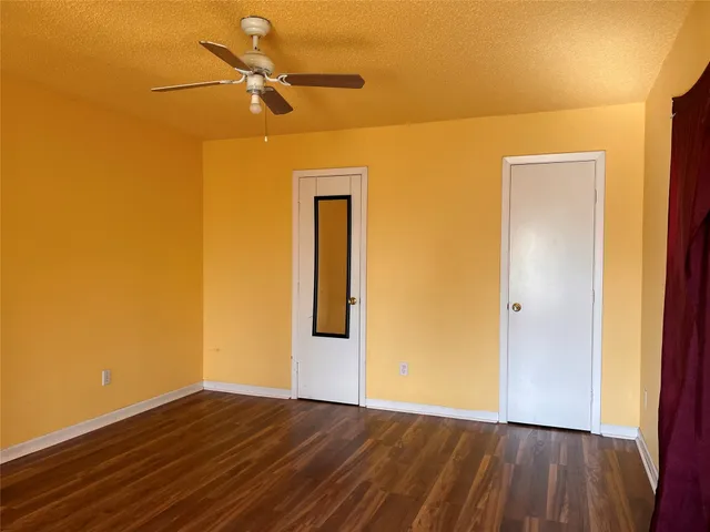 a view of a livingroom with a wooden floor and a ceiling fan