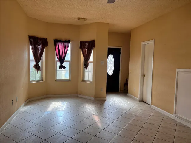 an empty room with windows and mirror