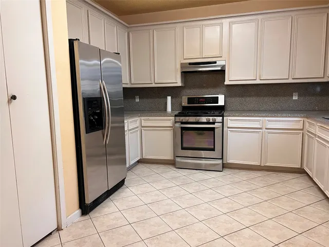 a kitchen with cabinets a refrigerator and a stove