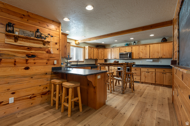 1505 West Elk Ridge Drive Alton, UT 84710 - Photo 6 of 53 Kitchen with a textured ceiling, recessed lighting, a peninsula, a breakfast bar area, and dark countertops