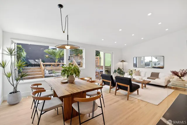 a dining room with furniture potted plants and wooden floor