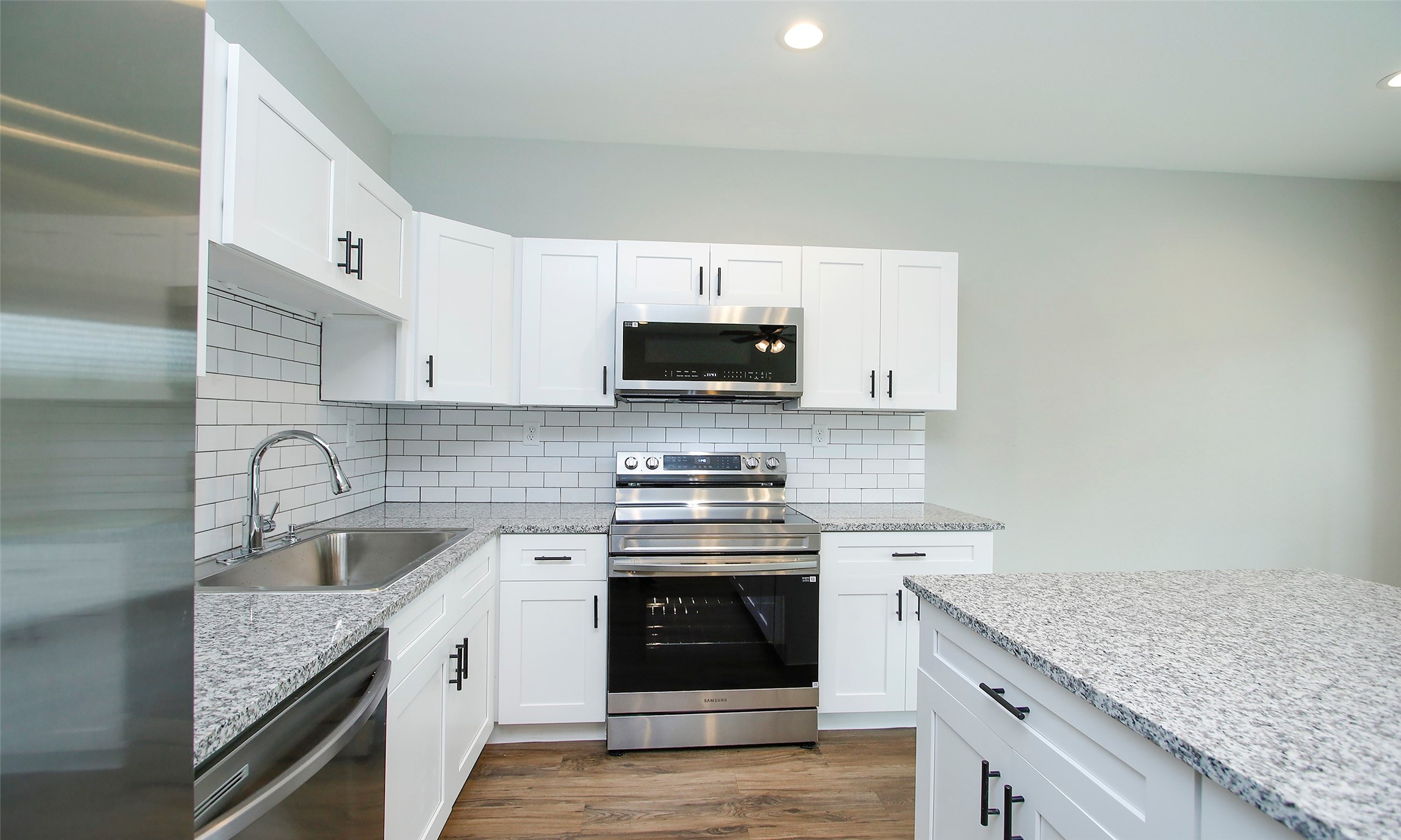14010 Longstreet Road, Unit 1B Willis, TX 77318 - Photo 13 of 44 a kitchen with granite countertop a stove sink and cabinets