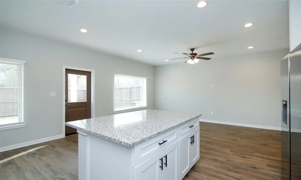 a kitchen with a sink chandelier and wooden floor