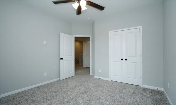 an empty room with chandelier fan