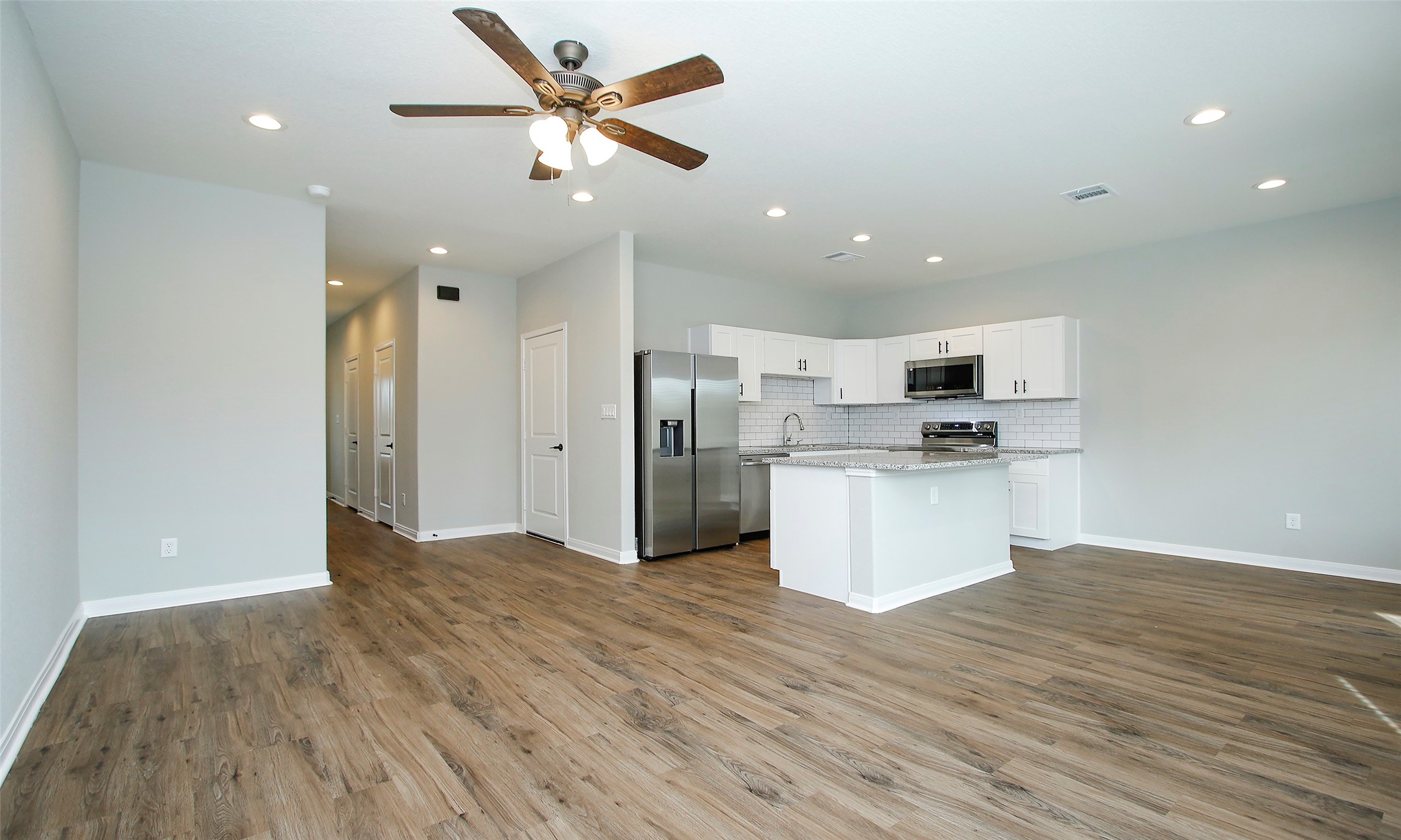 14010 Longstreet Road, Unit 1B Willis, TX 77318 - Photo 9 of 44 a view of kitchen with stainless steel appliances kitchen island wooden floors and white walls