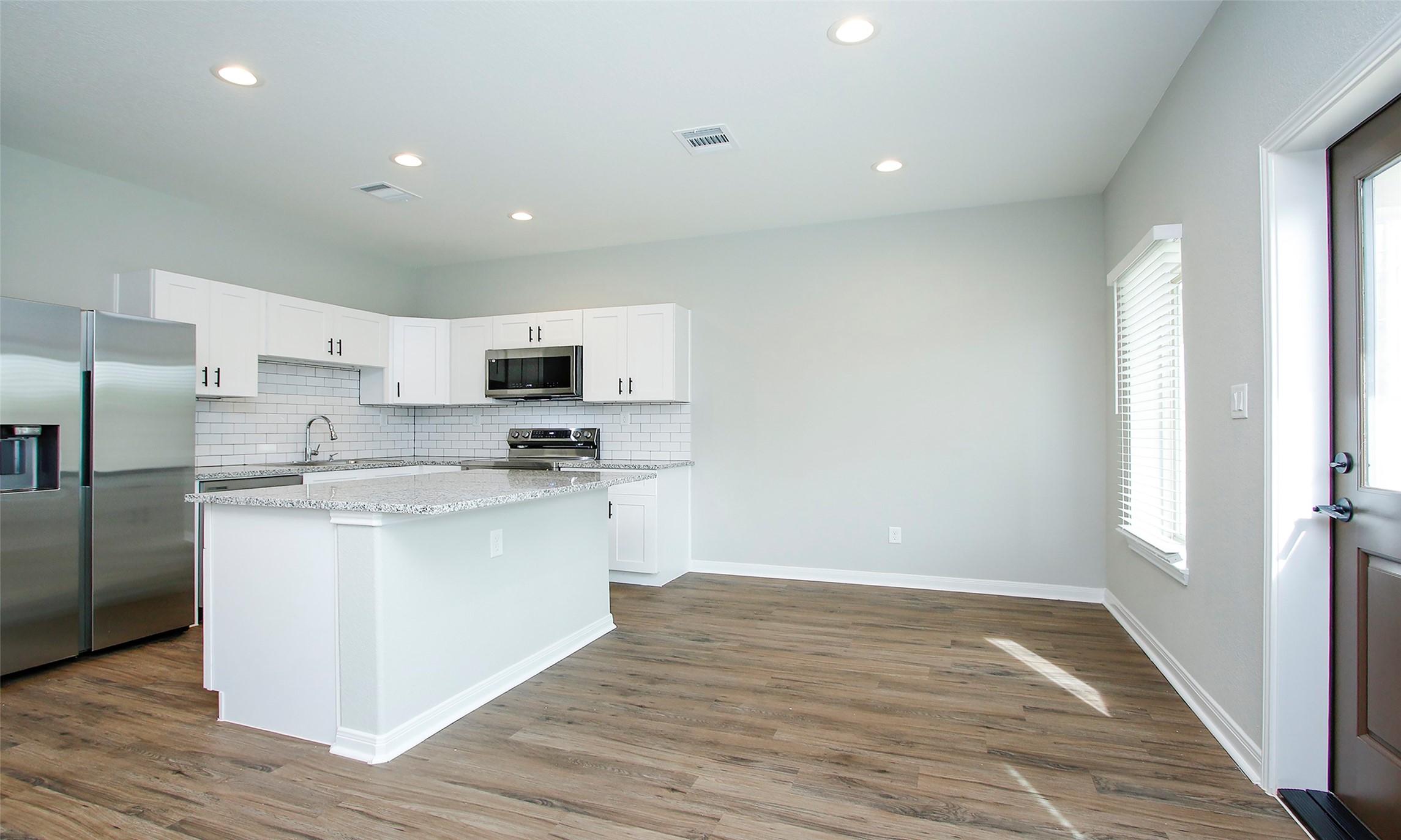14010 Longstreet Road, Unit 1B Willis, TX 77318 - Photo 10 of 44 a kitchen with stainless steel appliances granite countertop a refrigerator sink and white cabinets