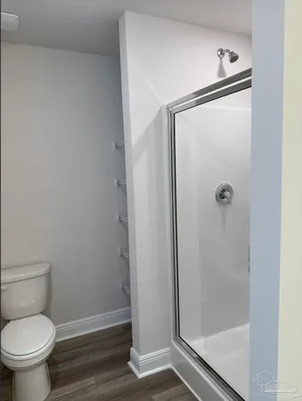 a bathroom with a granite countertop toilet and a shower