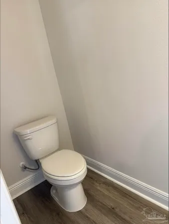 a white toilet sitting next to a white wall