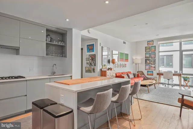 a room with stainless steel appliances kitchen island granite countertop furniture and a large window