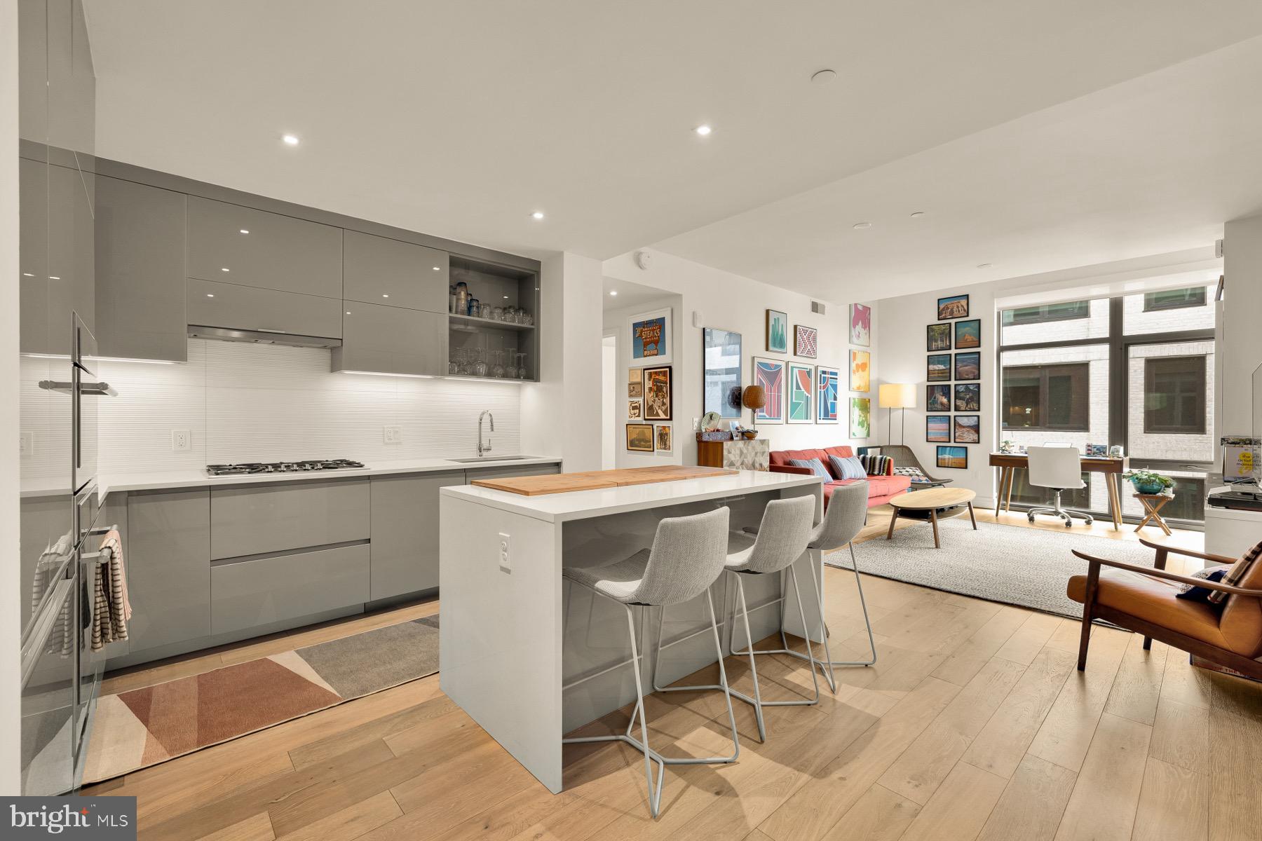 810 O Street Northwest, Unit 809 Washington, DC 20001 - Photo 2 of 30 a open kitchen with stainless steel appliances kitchen island granite countertop a sink and cabinets