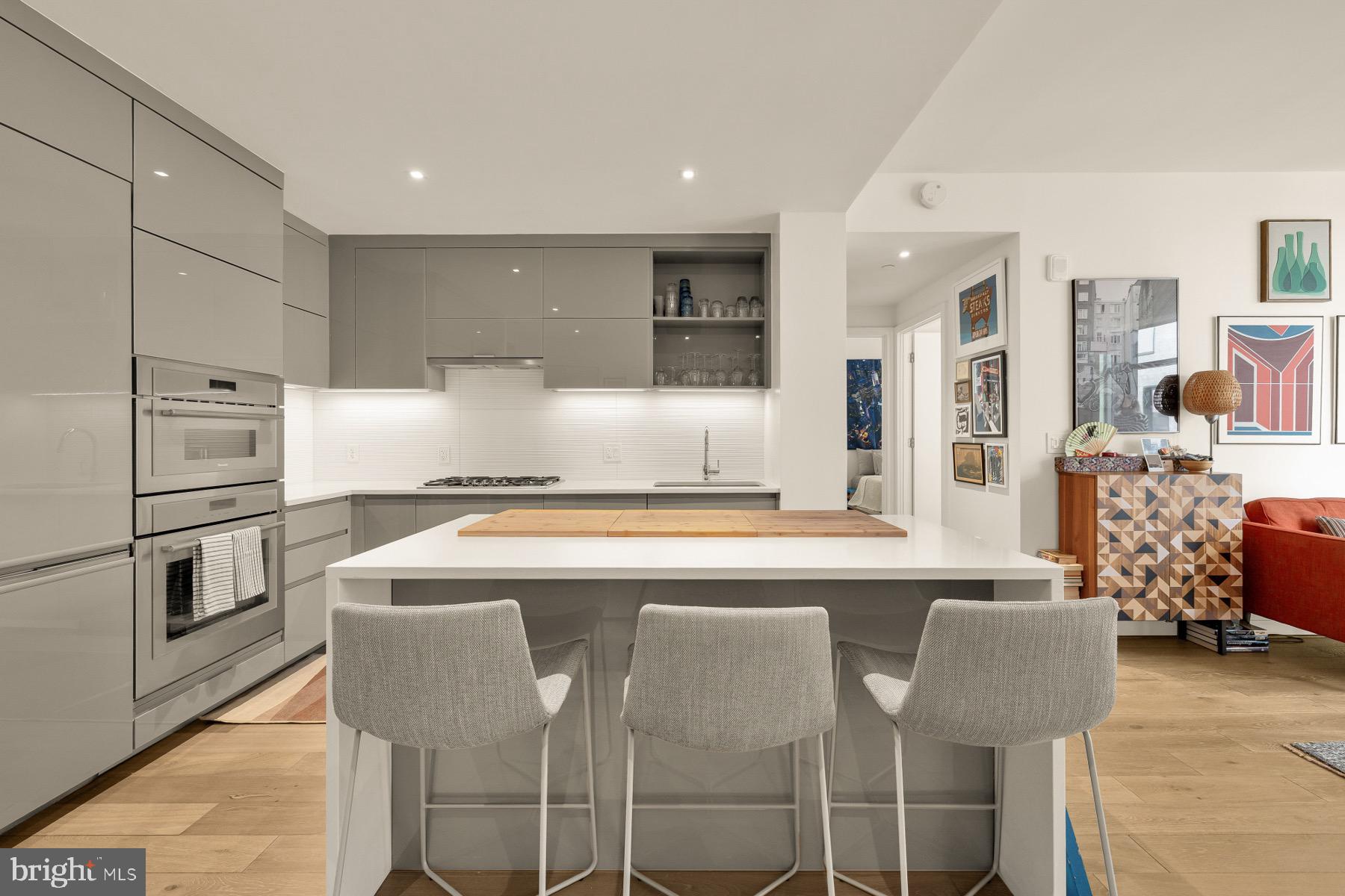 810 O Street Northwest, Unit 809 Washington, DC 20001 - Photo 3 of 30 a kitchen with stainless steel appliances granite countertop a table chairs refrigerator and sink