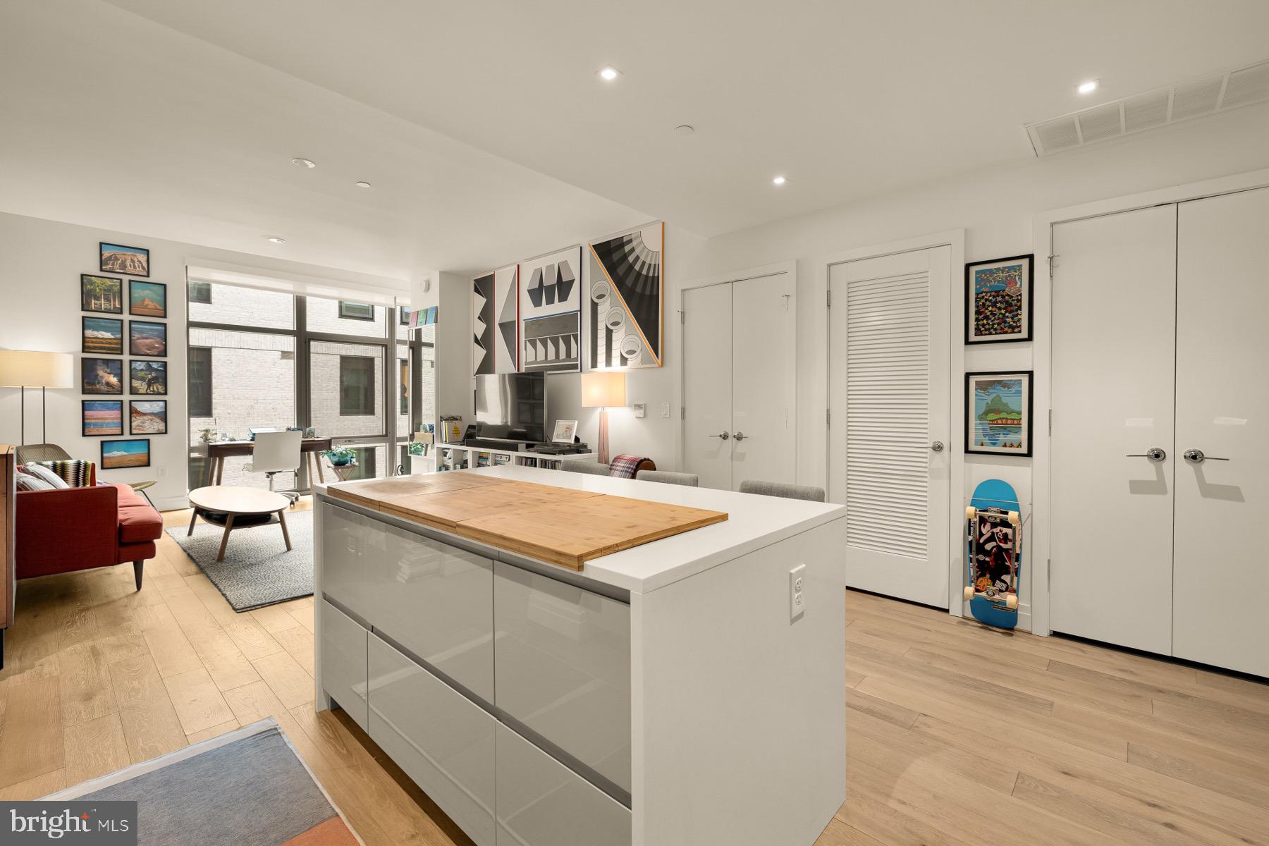 810 O Street Northwest, Unit 809 Washington, DC 20001 - Photo 7 of 30 a hall with kitchen island a stove a couch and a large window