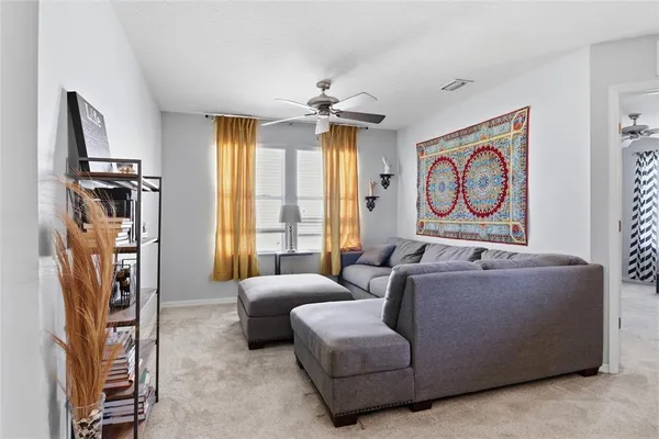 a living room with furniture a window and a flat screen tv