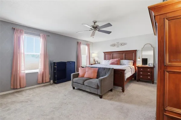 a living room with furniture and a ceiling fan