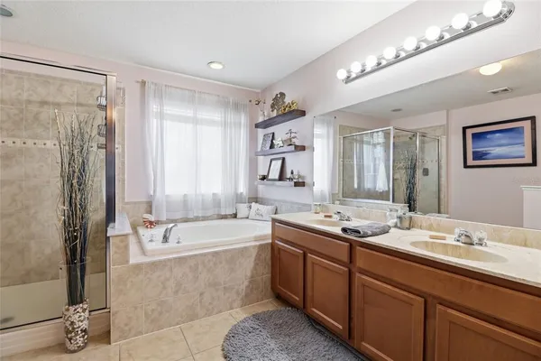 a bathroom with double vanity sinks double vanity tub shower and a mirror