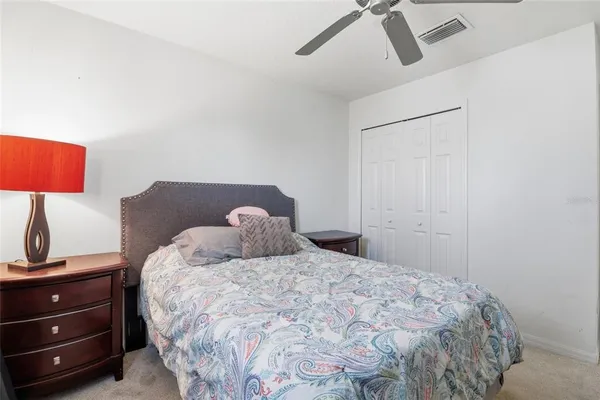a bedroom with a bed and a lamp on the dresser