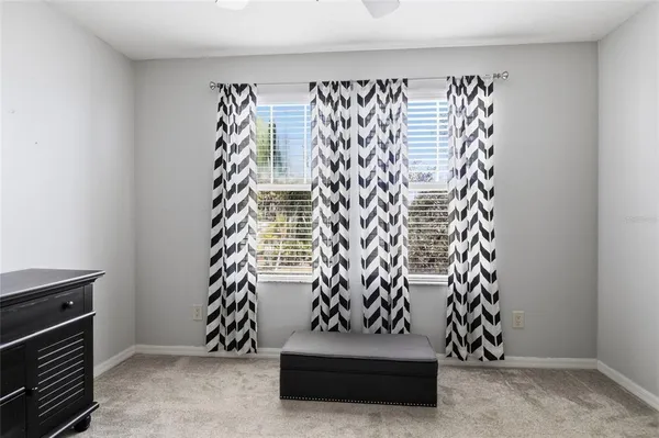 a view of an empty room with closet and windows
