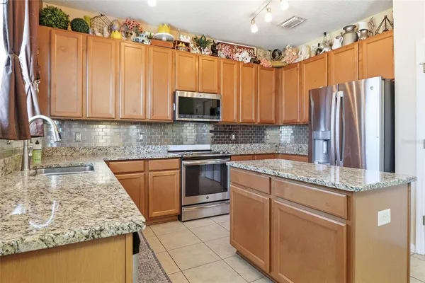 a kitchen with stainless steel appliances granite countertop a sink refrigerator and microwave