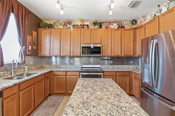 a kitchen with stainless steel appliances granite countertop a refrigerator and a sink