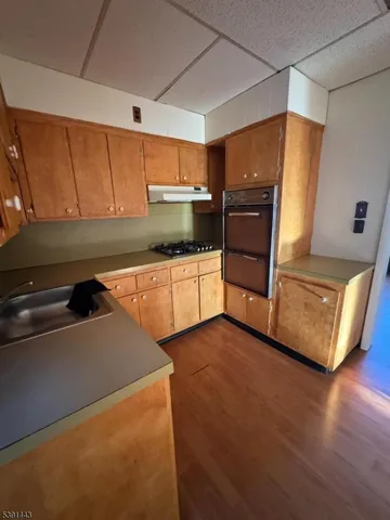 a kitchen with granite countertop a refrigerator and a stove top oven