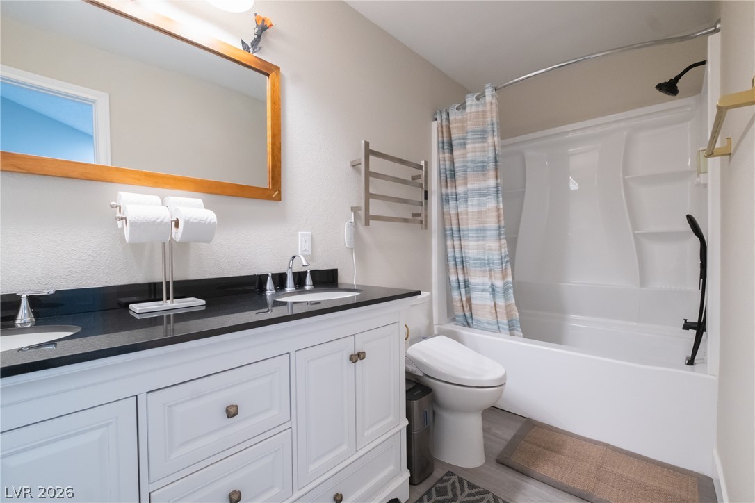 6356 West Viking Road Las Vegas, NV 89103 - Photo 27 of 51 Polished stone counters and clean white cabinetry elevate this updated bathroom.