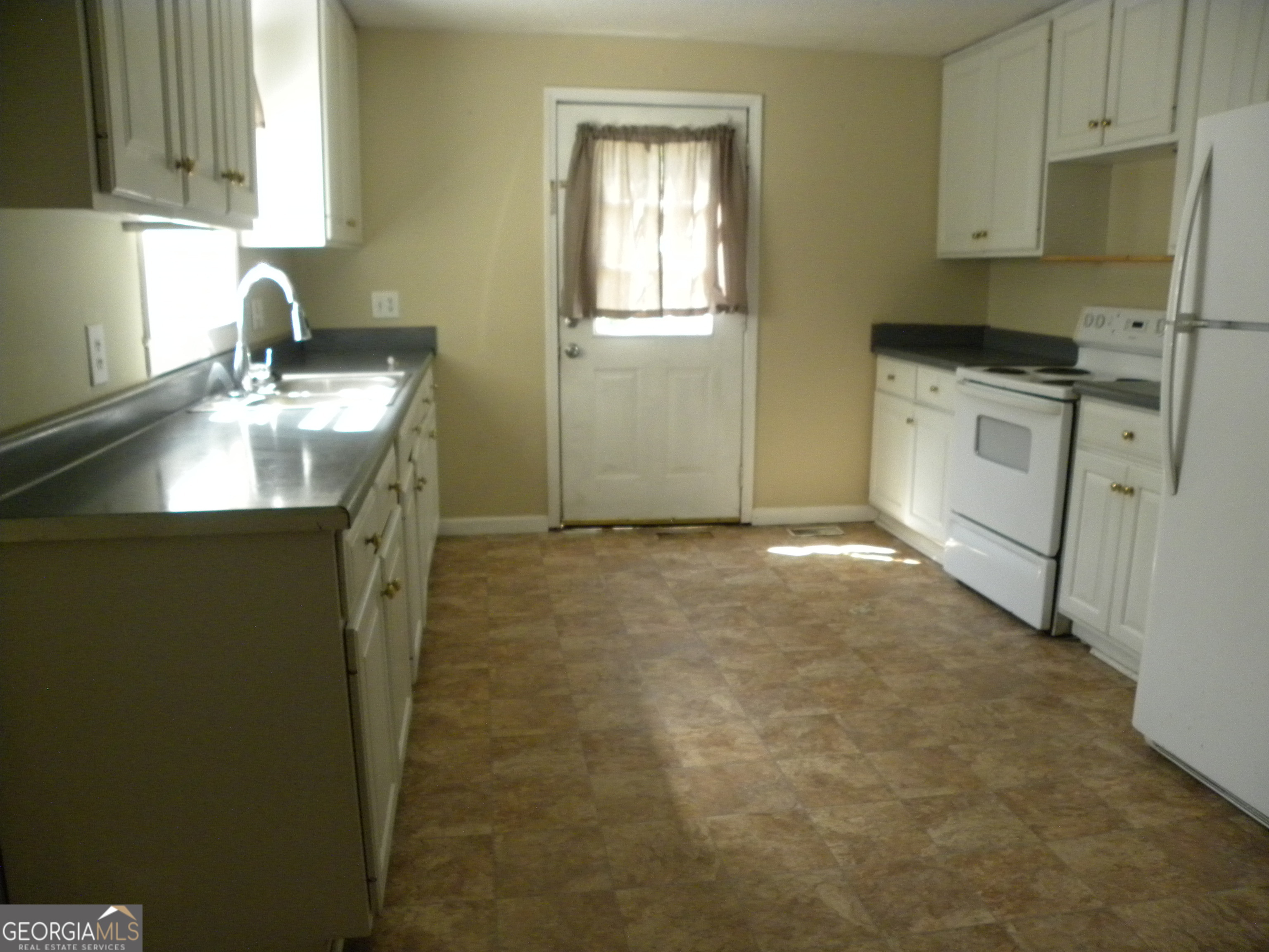 225 South Webb Street Hartwell, GA 30643 - Photo 15 of 24 a kitchen with granite countertop a sink a stove a refrigerator a window and cabinets
