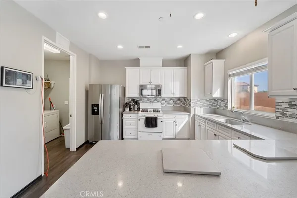 a large kitchen with stainless steel appliances granite countertop a refrigerator and a sink