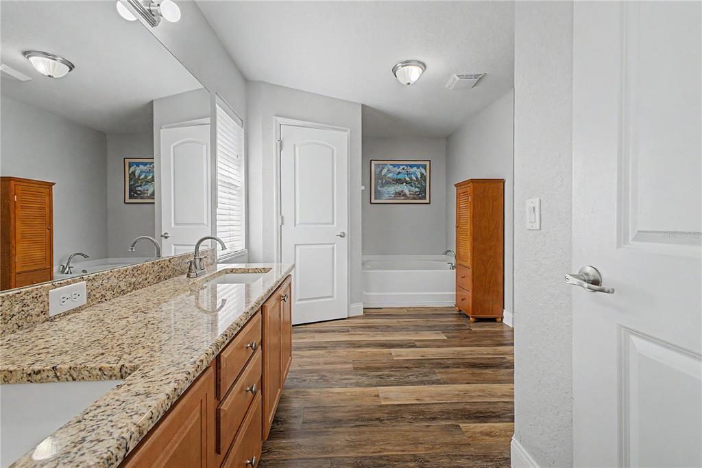 11213 Flock Avenue Weeki Wachee, FL 34613 - Photo 24 of 46 a bathroom with a granite countertop sink and a mirror