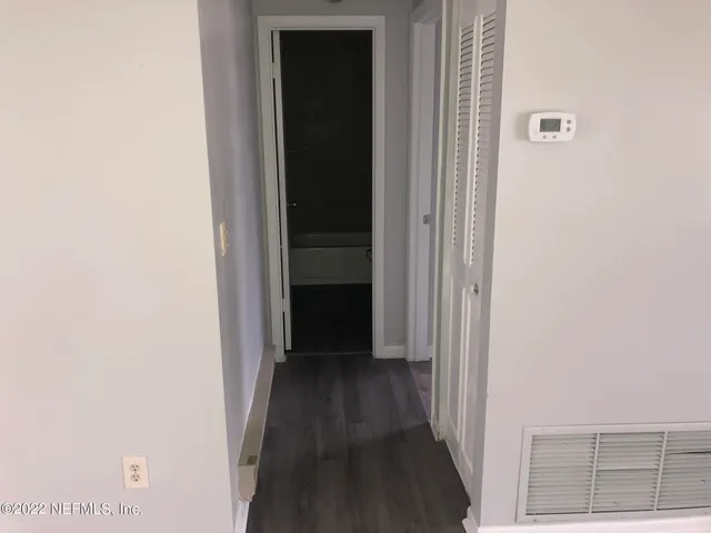 a view of a hallway with wooden floor