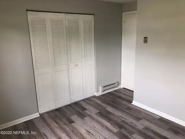 a view of an empty room with wooden floor
